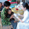 Nurse testing young boys blood in public health screening program 